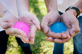 hands with blue and pink sand for gender reveal